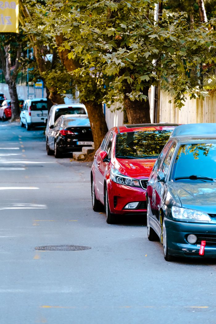 Parked cars under trees on a quiet Istanbul street, showcasing urban tranquility.